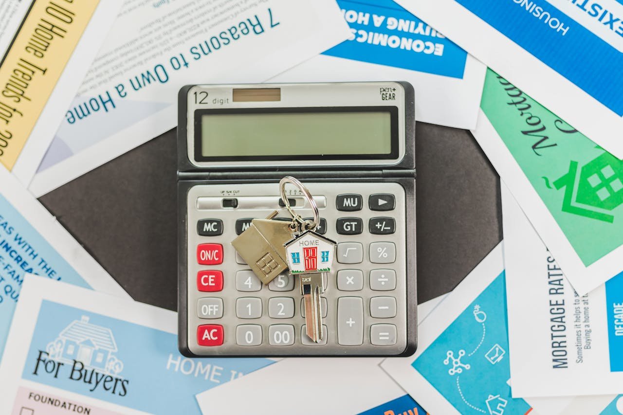 about-us-02 Calculator with keys and real estate documents symbolizes home buying finances.